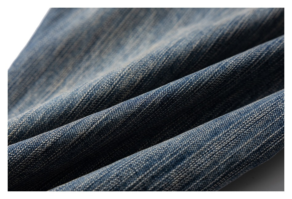 Macro view of textured blue denim with faded wash highlights and dark folds.
