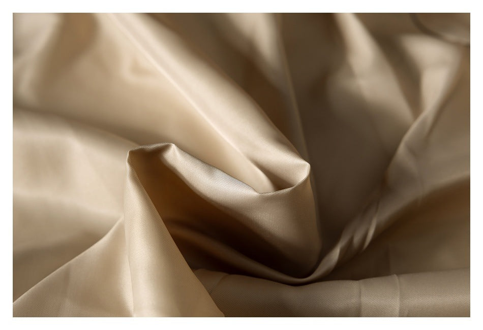 Close-up of smooth beige jacket lining draped in soft folds.