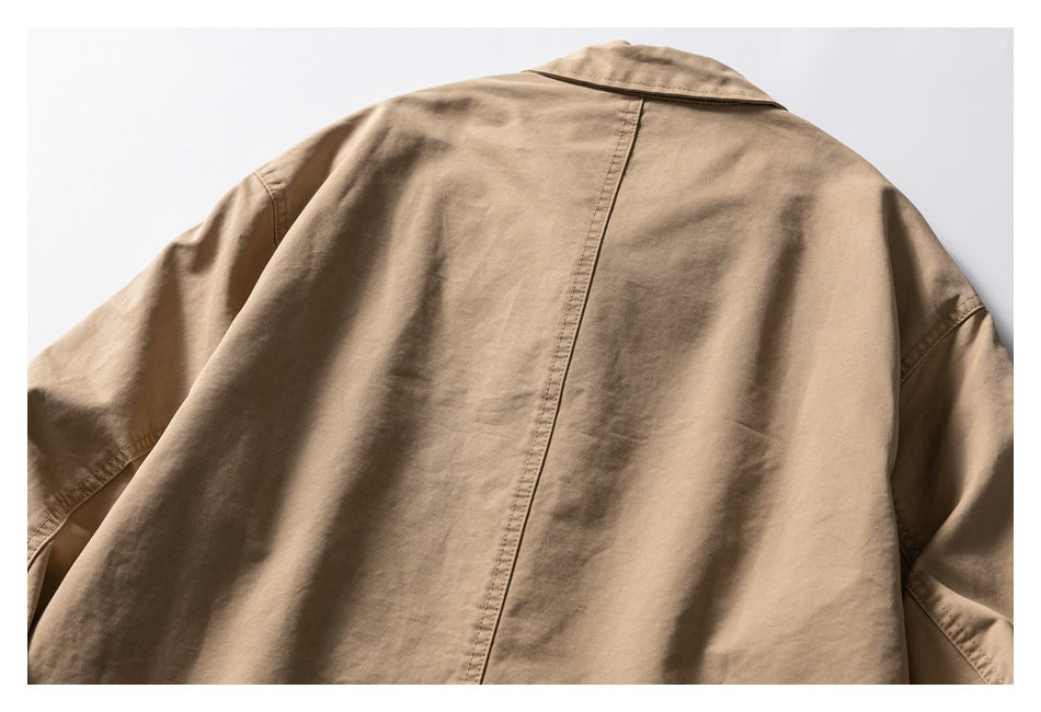 Back view of a tan jacket, showing its collar, center seam, and long sleeves.