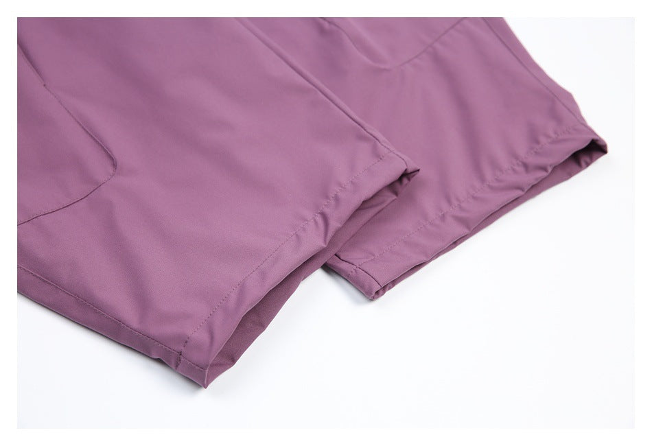 Close-up of purple trouser legs showing stitched hems and a side seam.