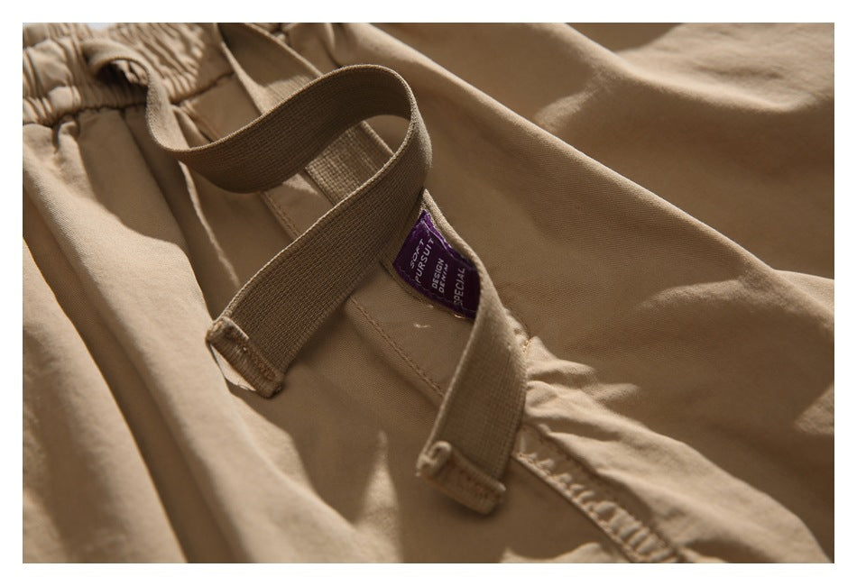 Close-up of tan shorts showing belt loops and a small purple label at the waistband.