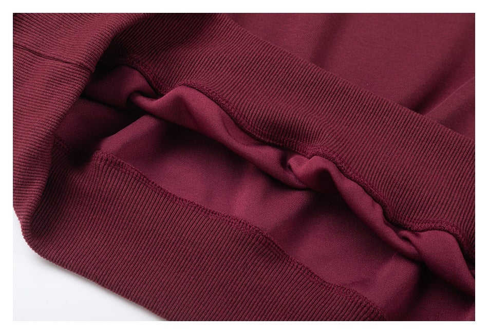 Close-up of the burgundy garment's ribbed hem and stitched seam.