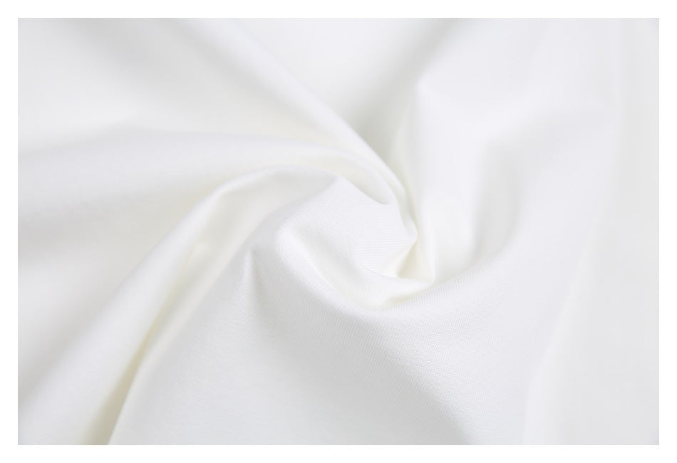 Close-up of white T-shirt fabric gathered into soft folds.
