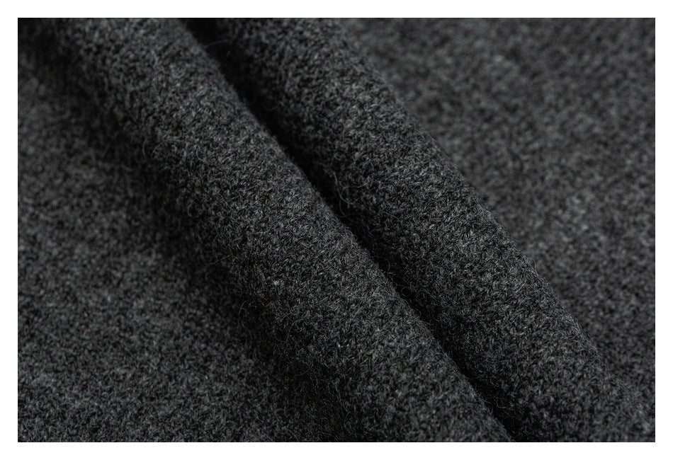 Close-up of dark charcoal knit fabric showing its textured stitches and a diagonal fold.