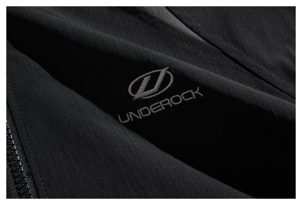 Close-up of black embroidered UNDEROCK branding beside the jacket's zipper.