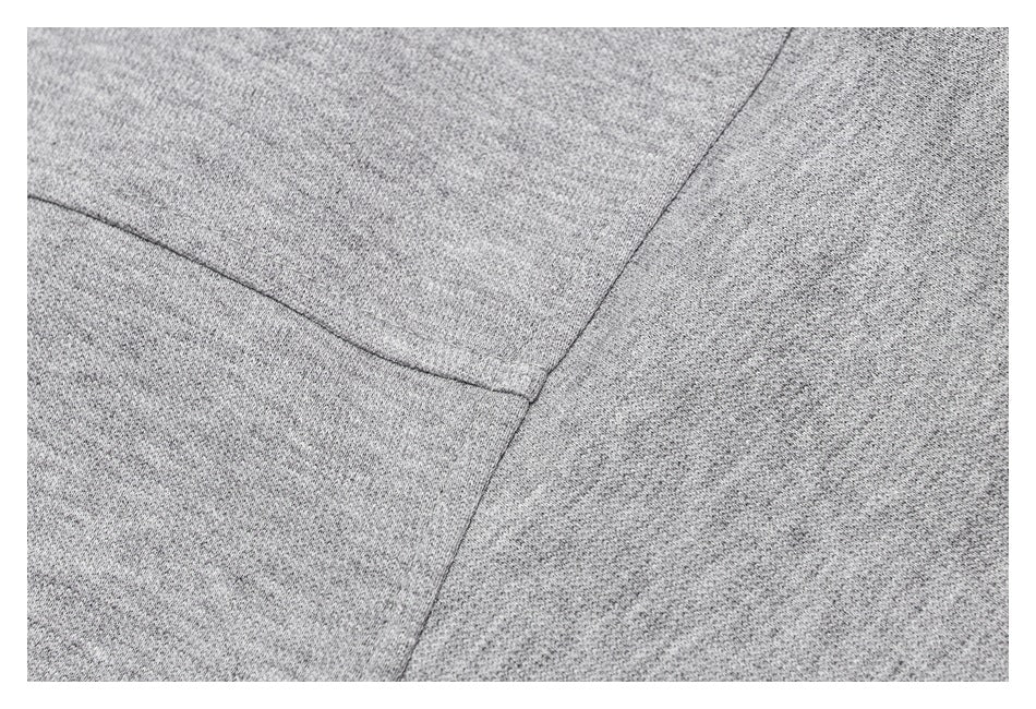 Close-up of intersecting stitched seams on heather-gray garment fabric.
