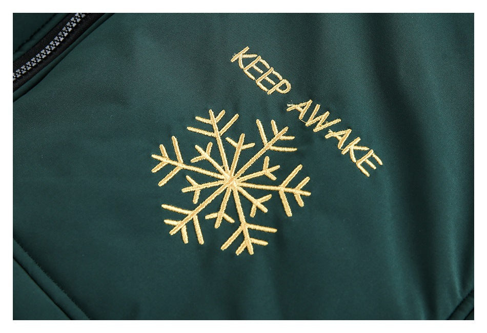 Gold embroidered “KEEP AWAKE” lettering and a snowflake on dark green jacket fabric.