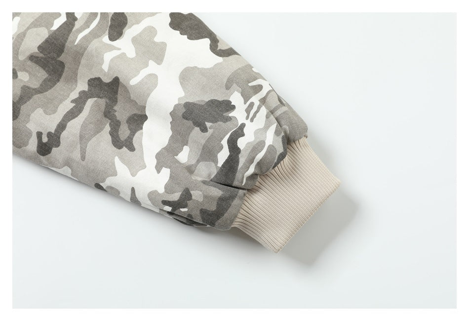Close-up of a gray and white camouflage jacket sleeve ending in a beige ribbed cuff.