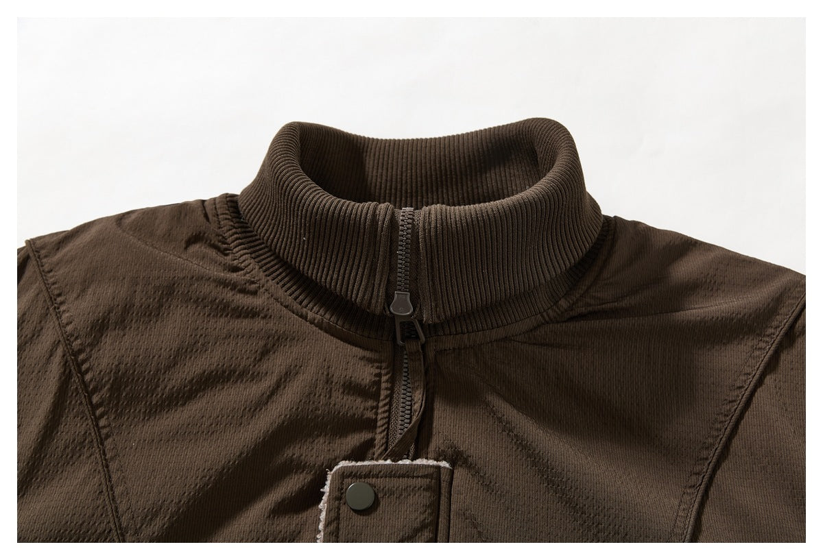 Close-up of a dark brown jacket's ribbed stand collar, front zipper, and snap-button placket.
