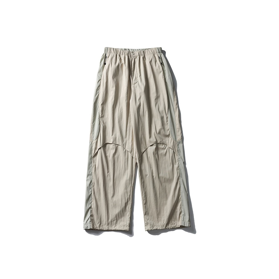 Front view of light beige wide-leg trousers with an elastic waist and curved panel seams.