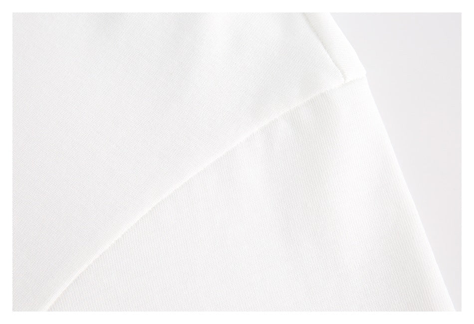 Close-up of white T-shirt fabric and a diagonal stitched seam.