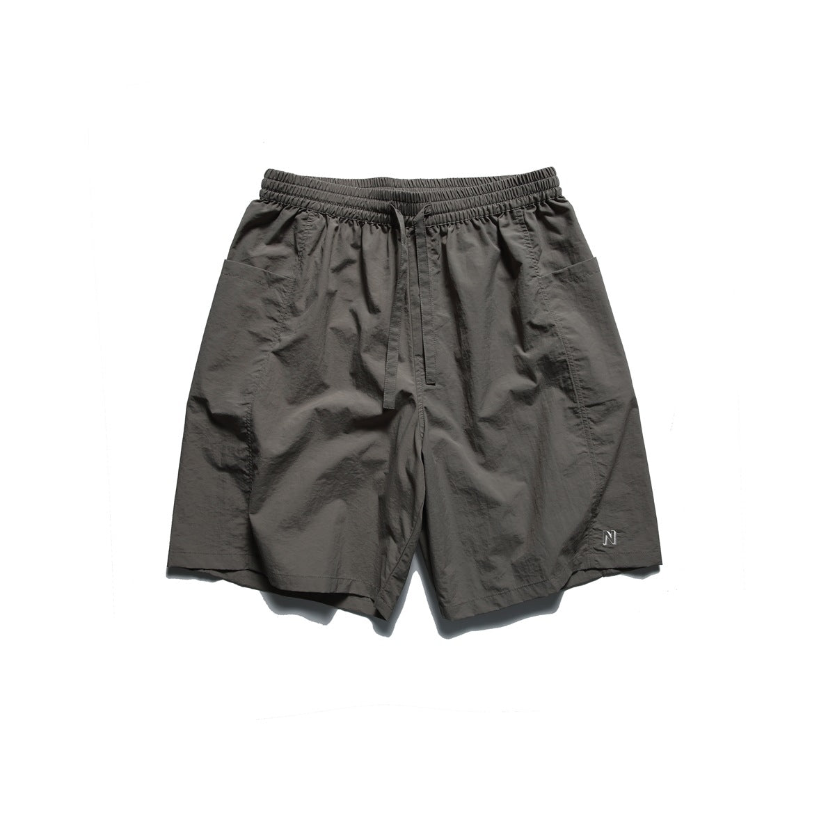 Dark gray shorts with crinkled fabric, drawstring waist, side patch pockets and embroidered N logo, flat lay