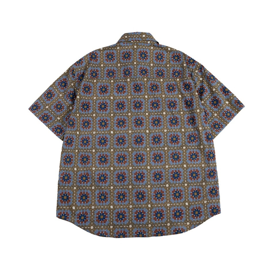 Back of a short-sleeve shirt with an all-over blue, rust and navy geometric floral print on olive brown