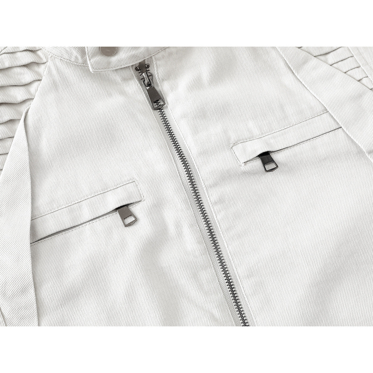 Close-up of an off-white jacket front with a metal zipper and two flap pockets with pull tabs.