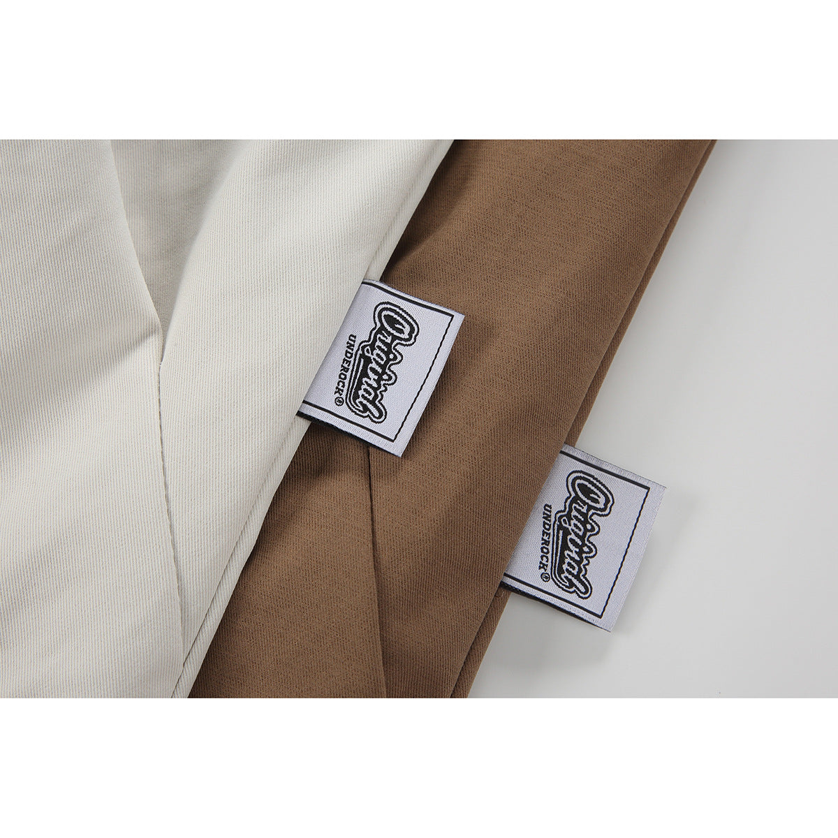 Close-up of ivory and brown jacket fabric with sewn-in woven labels.
