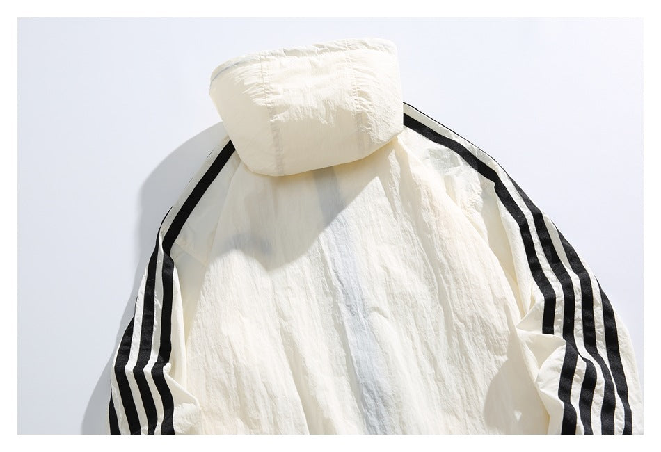 Close-up of an off-white hooded jacket with black triple stripes along the sleeves.