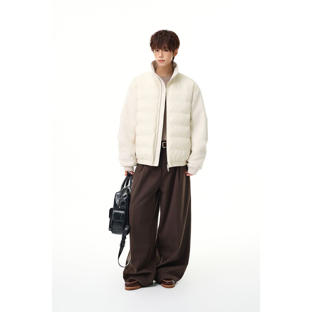 Model wearing an ivory quilted zip jacket with pale sleeves, styled with dark wide-leg trousers.