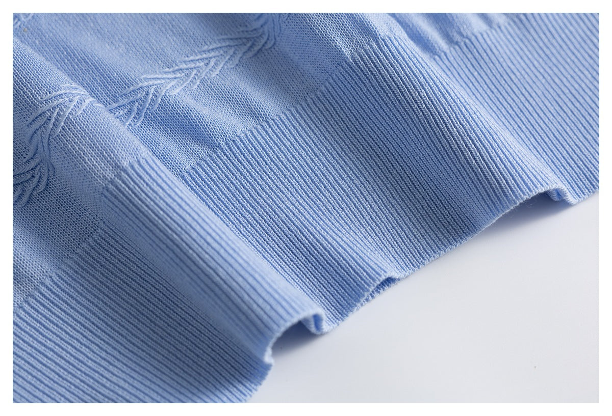 Close-up of the light blue sweater's wide ribbed hem and textured knit stitching.