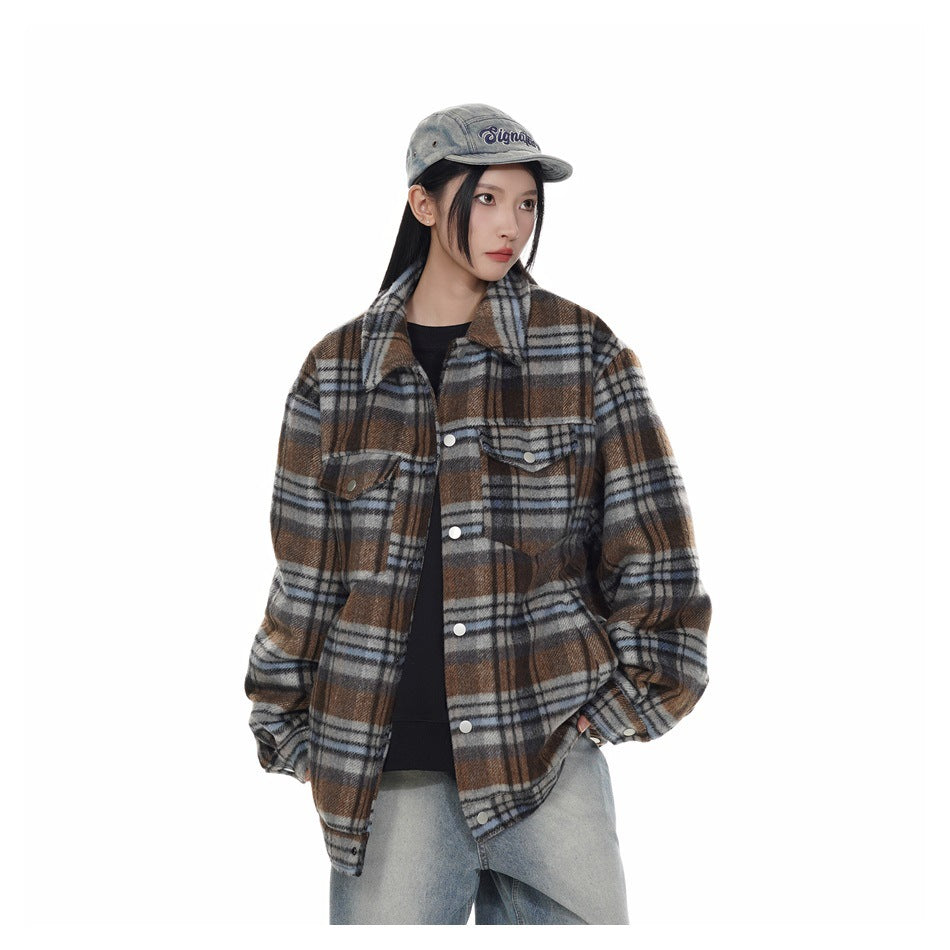 Model wearing blue and brown plaid snap-front jacket with cap and light jeans, three-quarter view