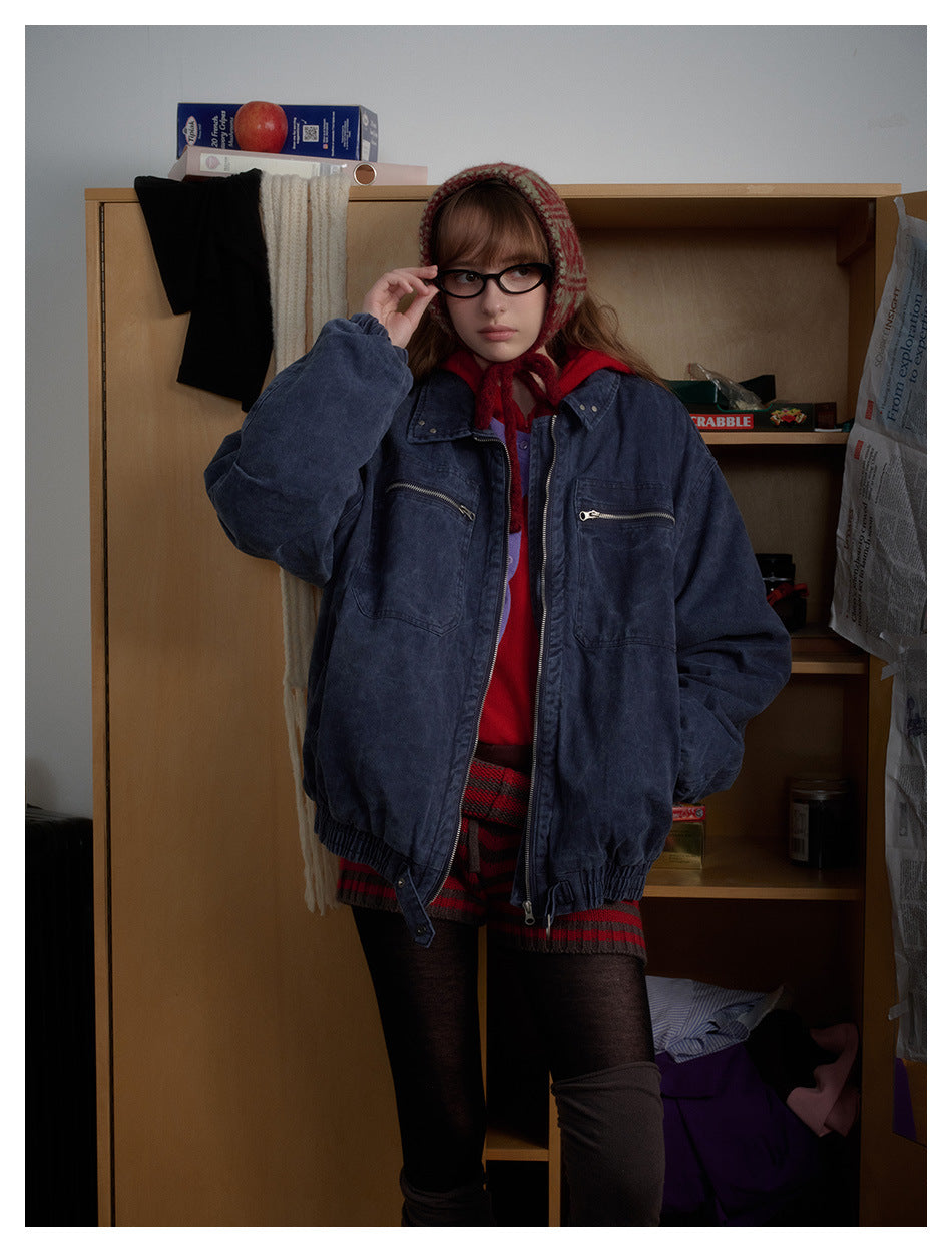 Model wearing an oversized navy washed jacket with a zip front and two zip chest pockets.