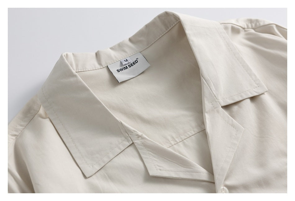 Close-up of the ivory shirt's open camp collar and sewn-in neck label.