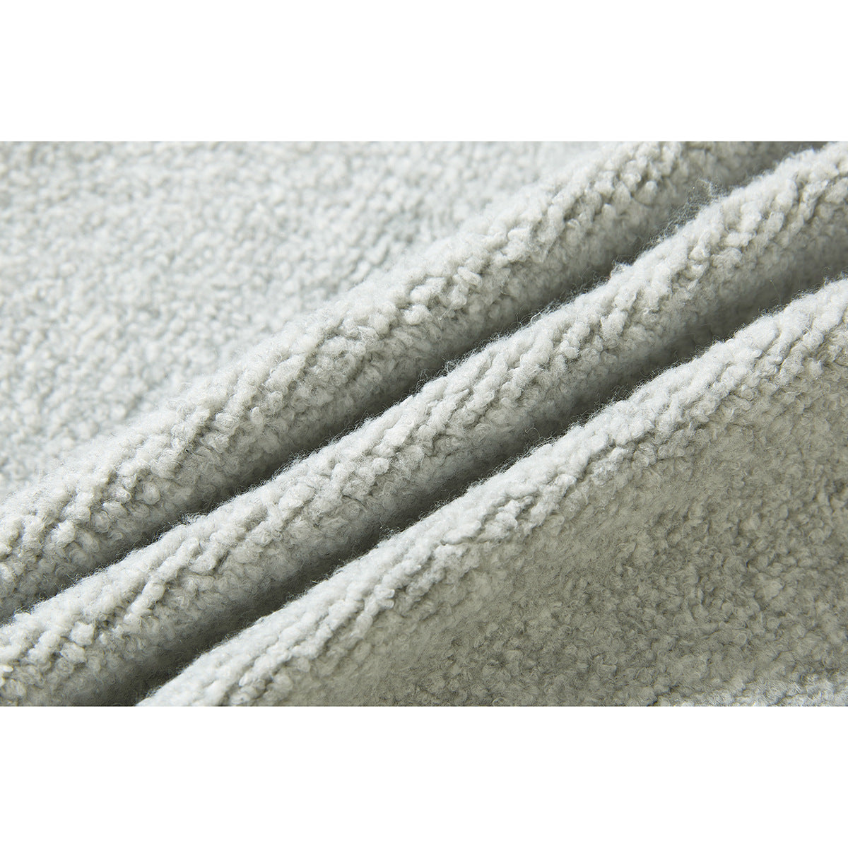 Extreme close-up showing the looped, textured knit of a light gray cardigan.