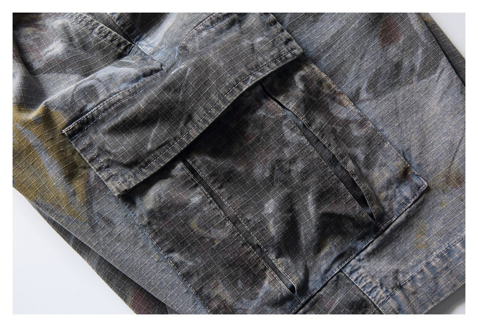 Close-up of a flap cargo pocket on dark gray plaid trousers.