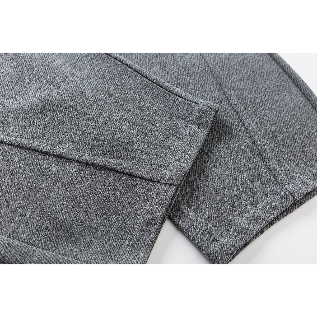 Close-up of gray pants fabric with a stitched seam and finished edge.