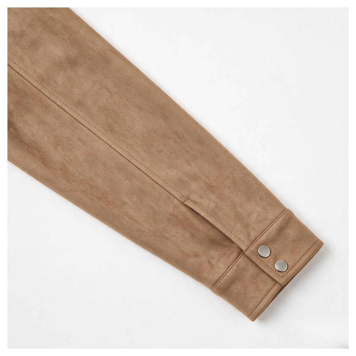 Close-up of a tan jacket sleeve and cuff with two silver snap buttons.