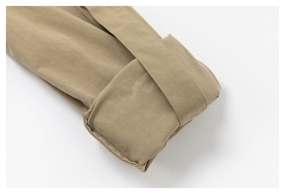 Close-up of a folded khaki shirt cuff and sleeve seam.