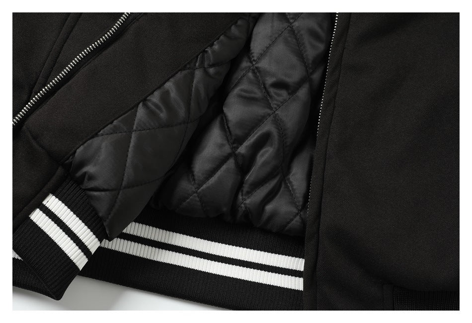 Close-up of a black jacket interior with diamond-quilted lining, a striped ribbed cuff and matching hem.