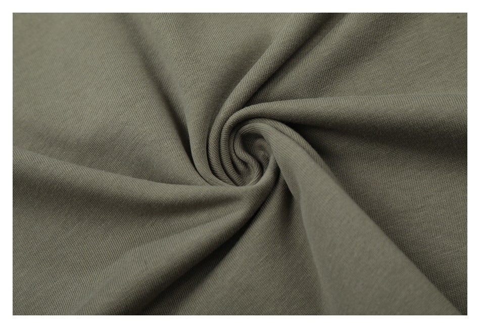 Close-up of olive-gray fabric gathered into soft folds, showing its surface texture.
