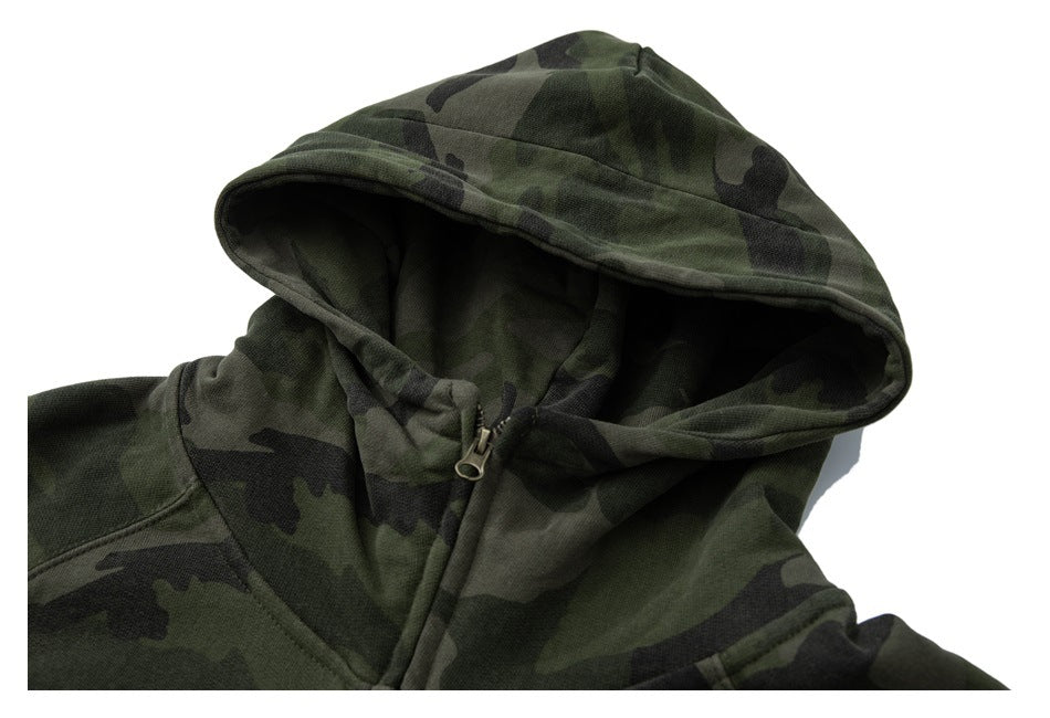 Close-up of an olive and black camouflage hoodie hood and upper zipper on a white background.