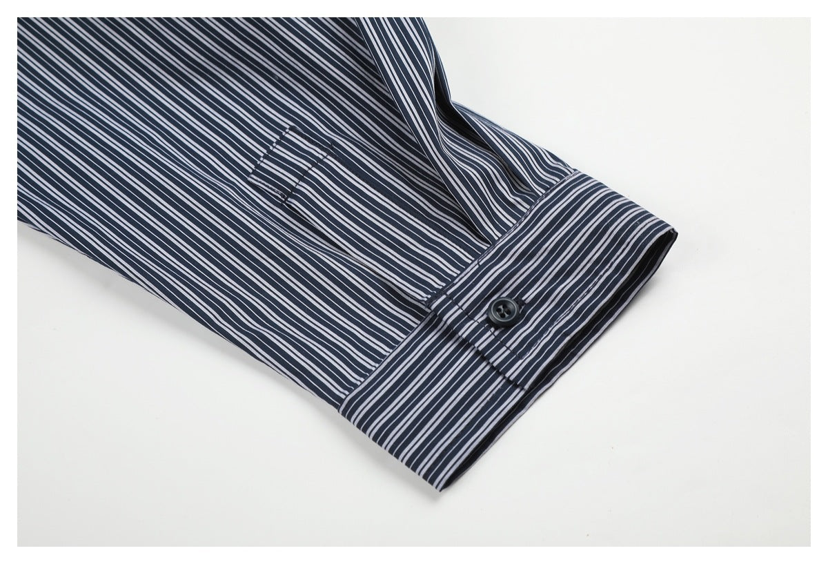 Close-up of a navy shirt sleeve with fine white stripes, a buttoned cuff, and a small stitched tab.