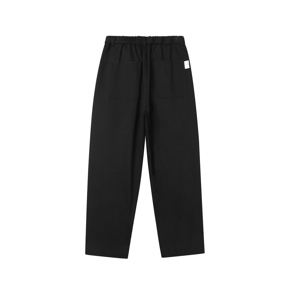 Rear view of black trousers with an elastic waistband and two patch pockets.
