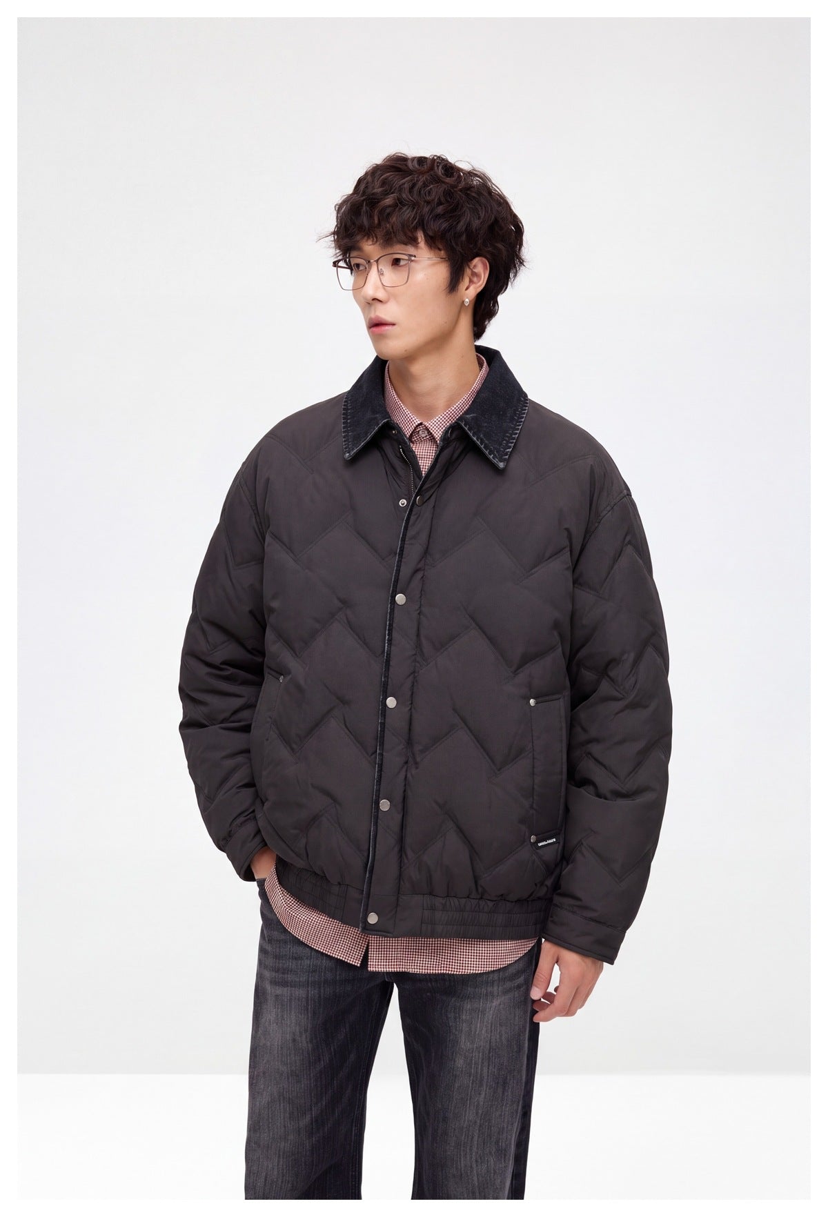 Model in a dark chevron-quilted jacket with a contrast pointed collar, snap front, and front pockets.