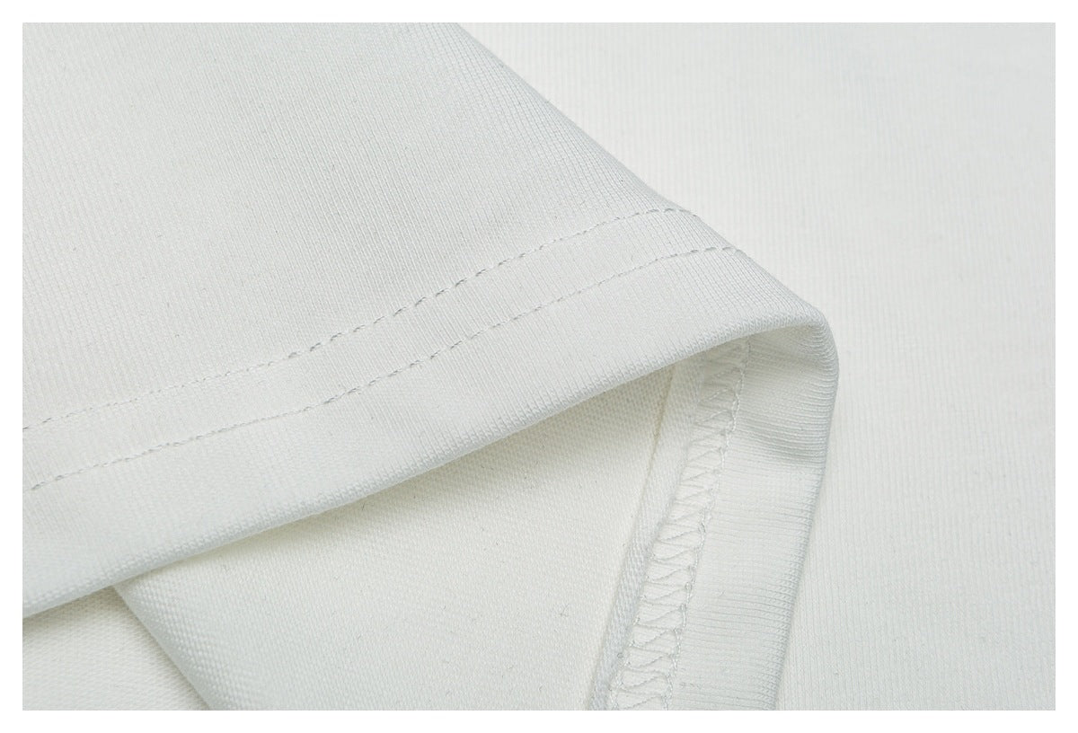 Close-up of a white garment hem showing double stitching and an overlocked seam.
