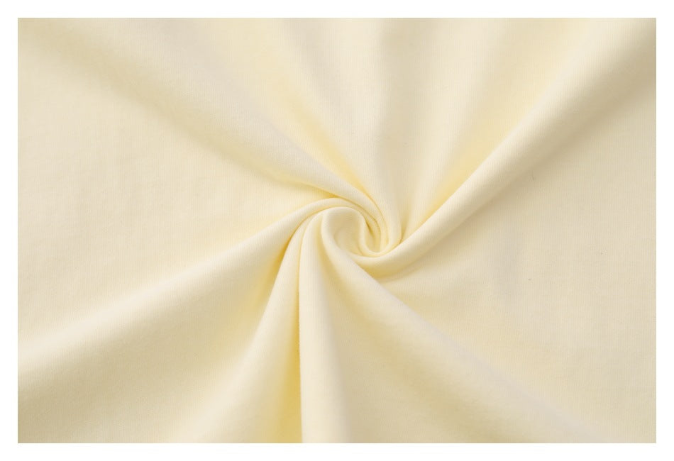 Extreme close-up of the cream shirt fabric gathered into a swirl.