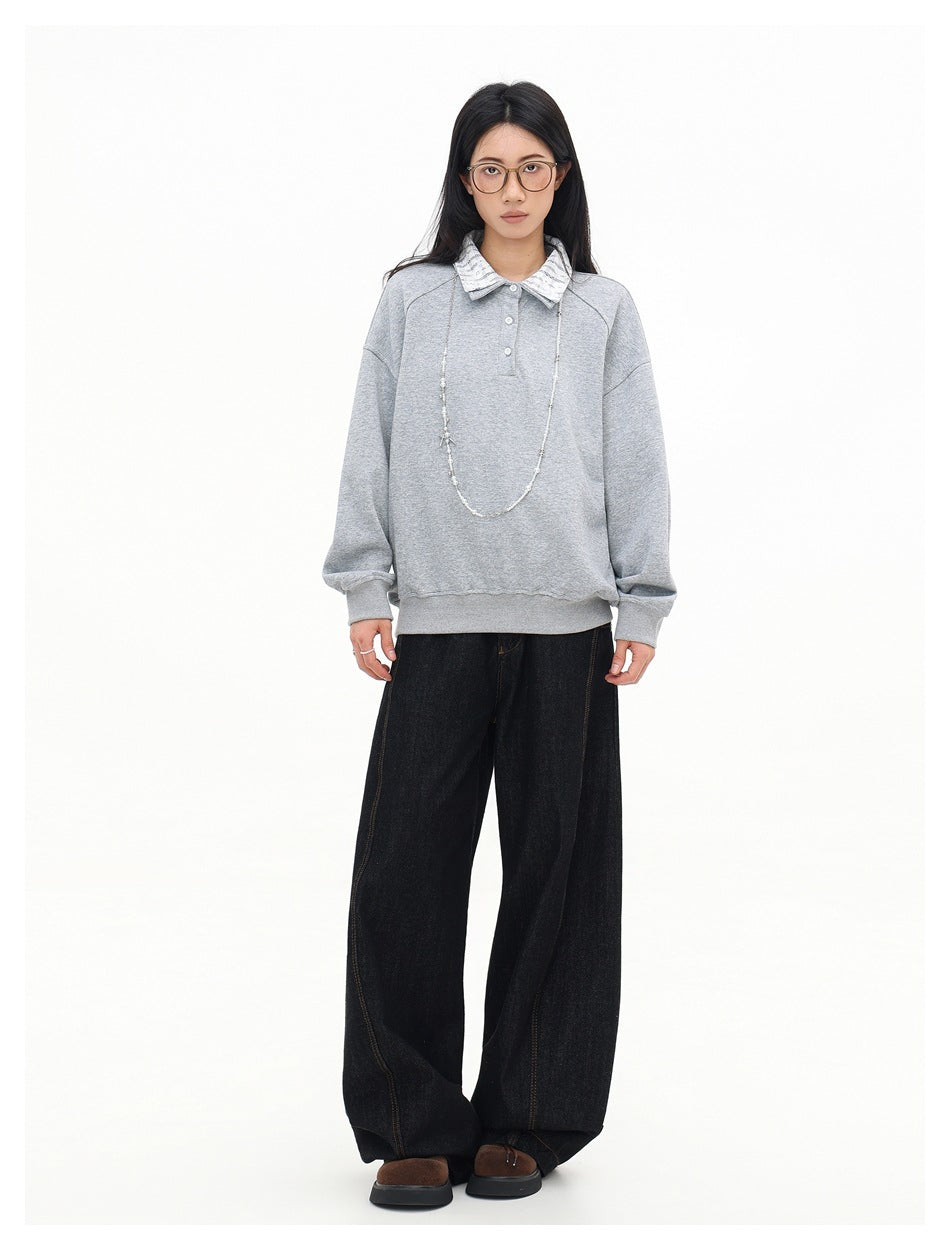 Front view of a model wearing a light gray collared pullover with a patterned collar and three-button placket.