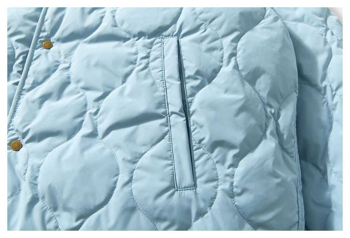 Close-up of the light blue jacket's quilted front and a narrow vertical welt pocket.