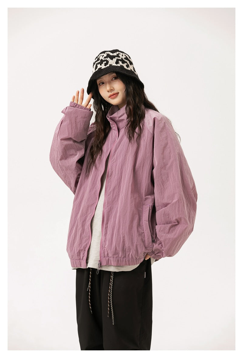 Model wearing a mauve oversized zip jacket with roomy sleeves and a raised collar.