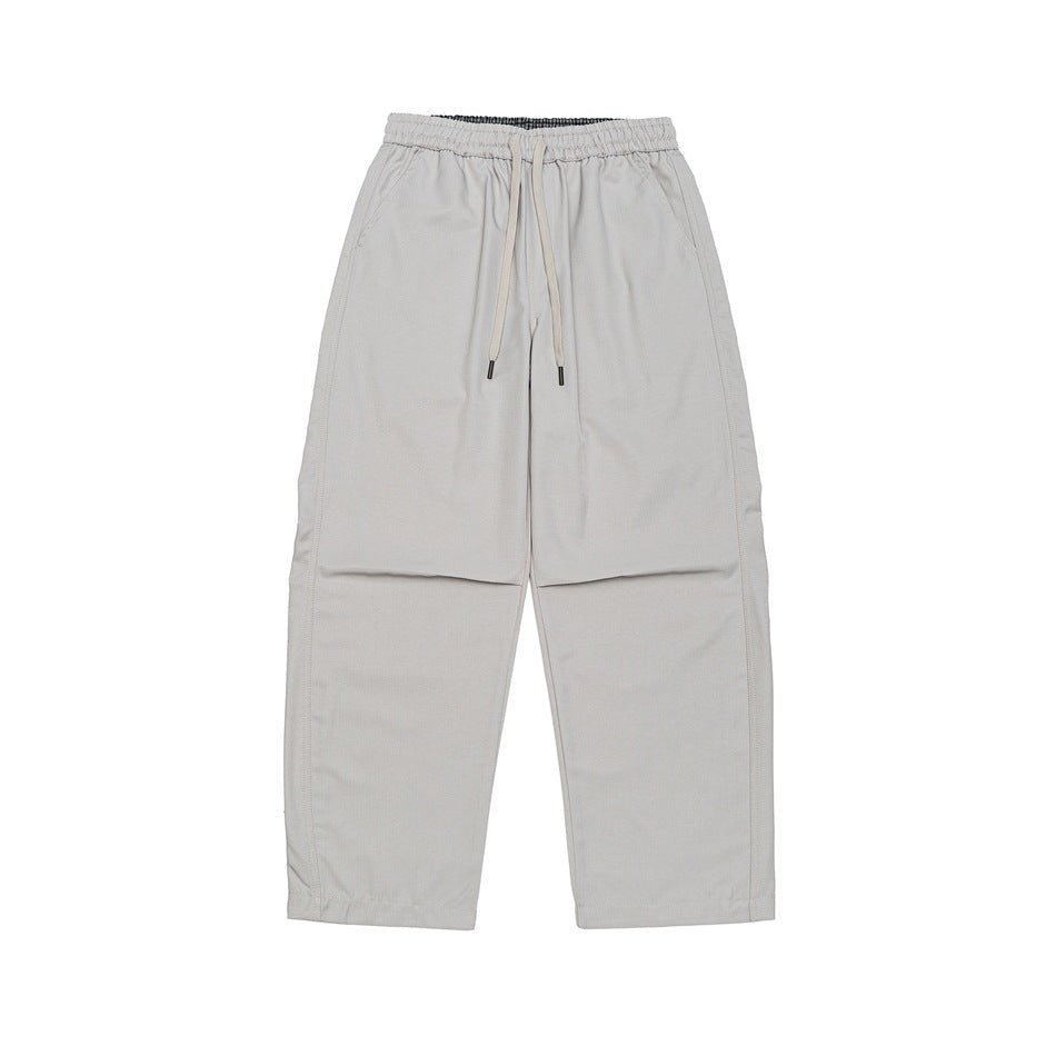 Flat-lay front of light beige-gray wide-leg drawstring pants with elastic waist and side pockets