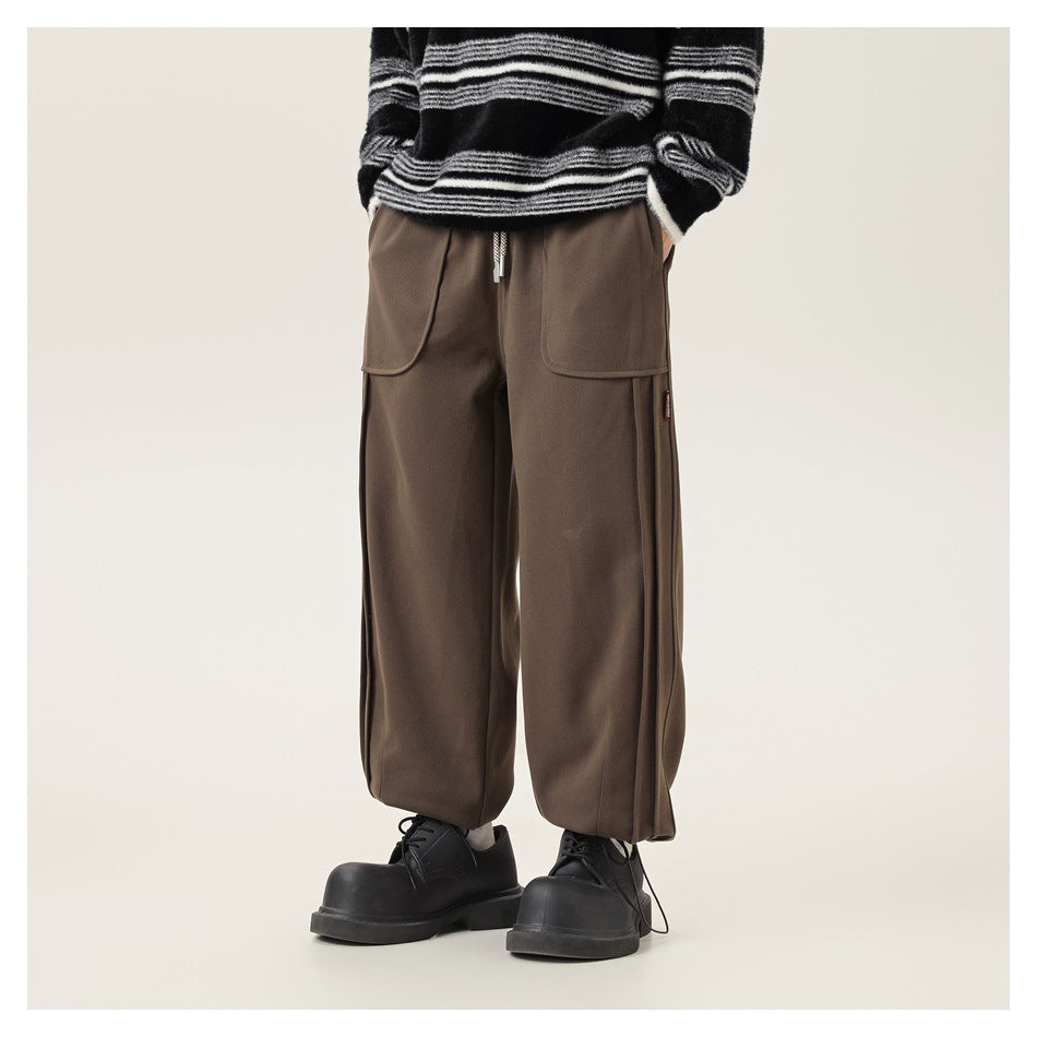 Front view of a model wearing brown wide-leg cargo pants with oversized pockets and an adjustable drawstring hem.