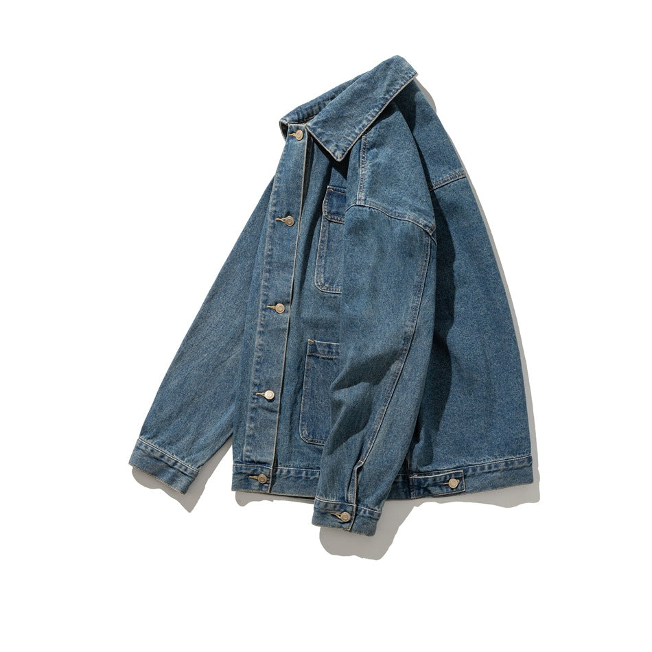 Angled front view of a blue denim jacket showing its button placket, collar, chest pocket, and large lower pockets.