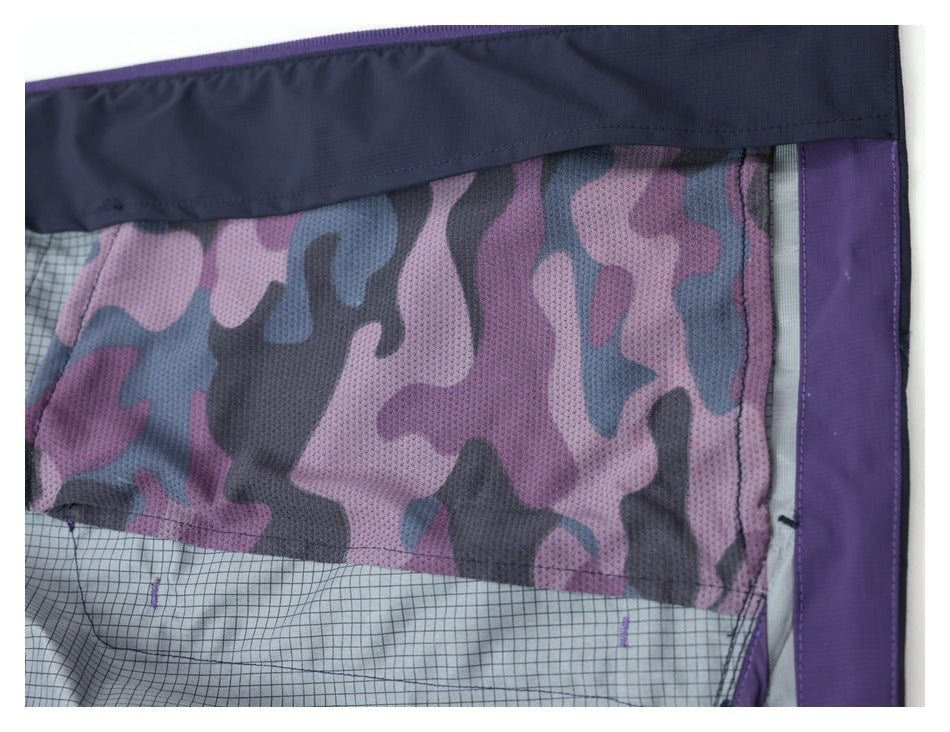 Inside close-up of the jacket showing pink, purple, gray and blue camouflage lining and a gridded inner panel.