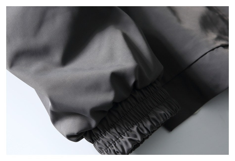 Close-up of a gathered elastic cuff on a charcoal-gray jacket sleeve.