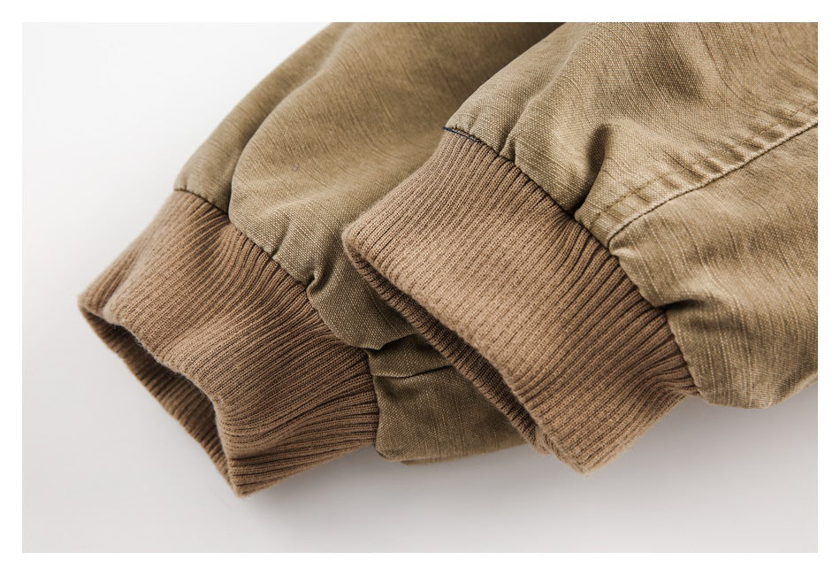 Close-up of tan sleeves with brown rib-knit cuffs and visible seams.