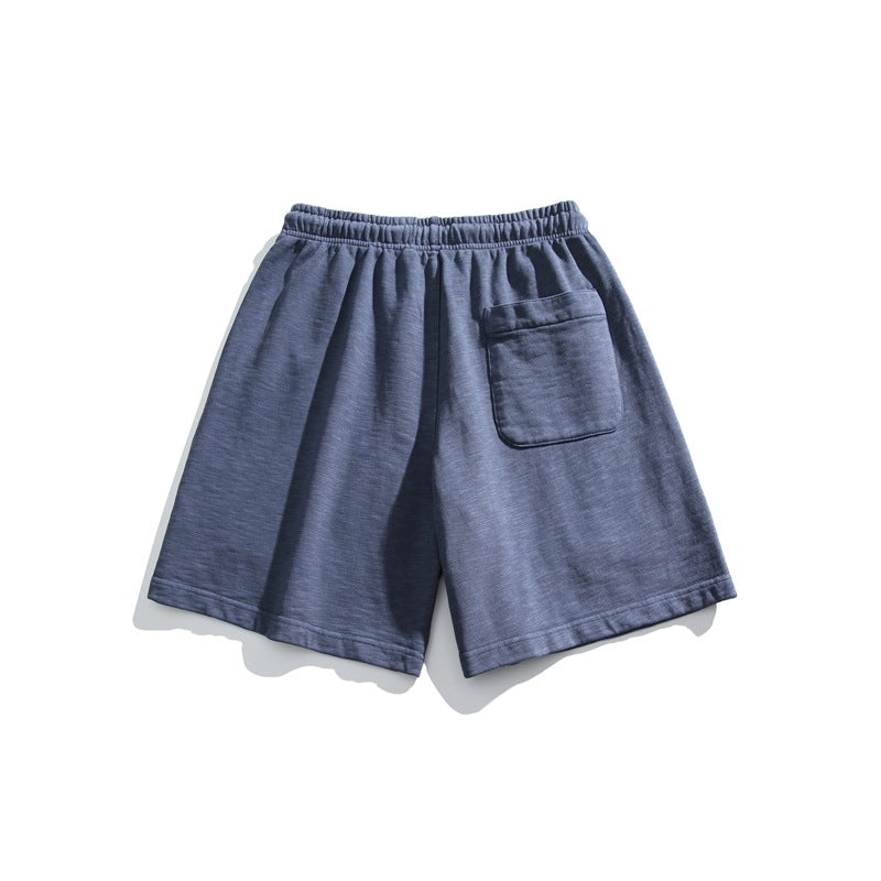 Blue-gray shorts shown from the back, with an elastic waistband and a single patch pocket.