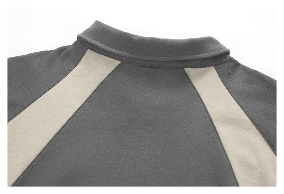 Close-up of a charcoal garment's back collar and shoulder, with two light beige inset panels.