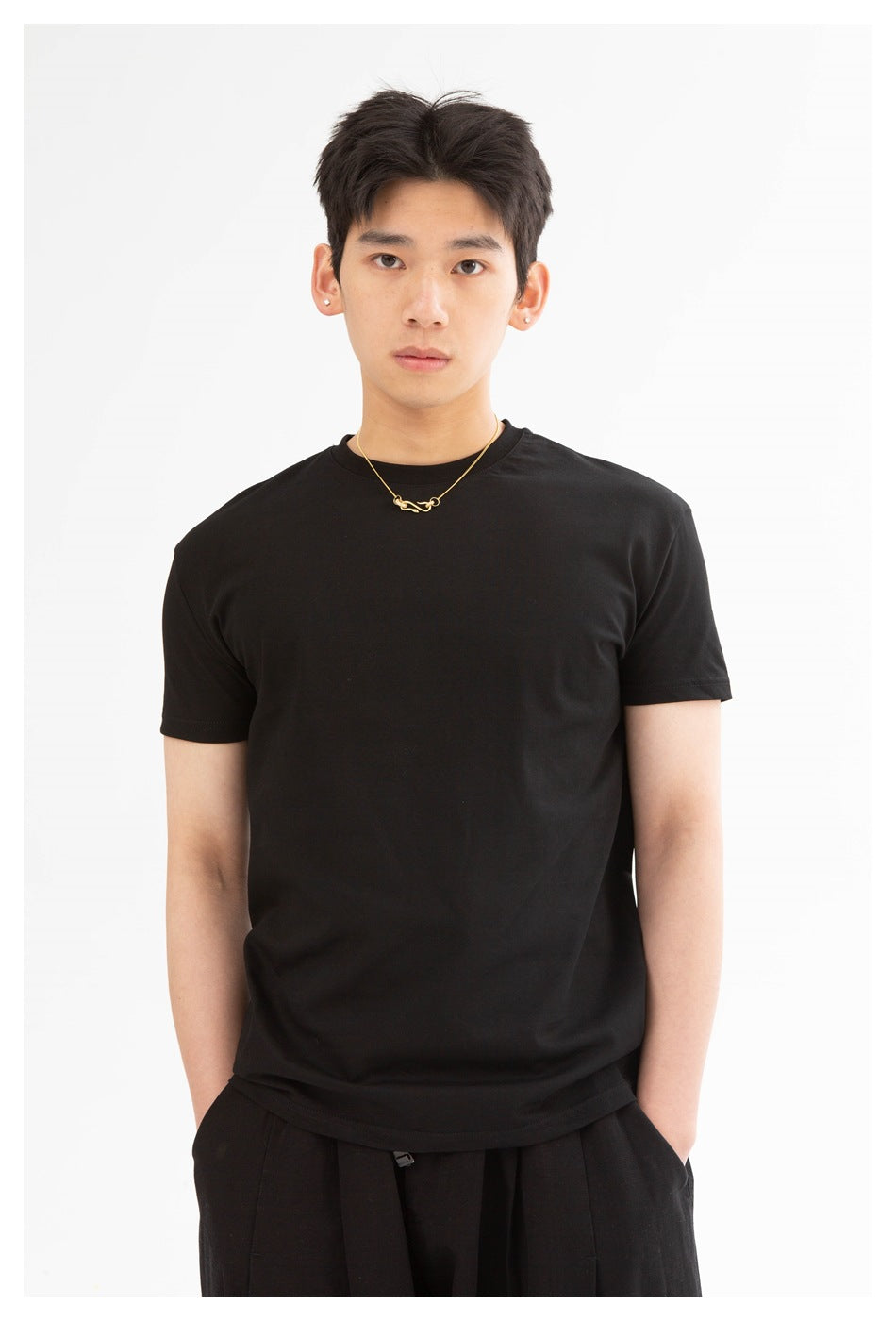 Front view of a model wearing a plain black crew-neck T-shirt.